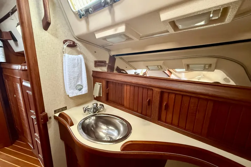 Blue Skies Yacht Photos Pics Interior of 1995 Island Packet 40 sailboat featuring wooden cabinetry and stainless steel sink.