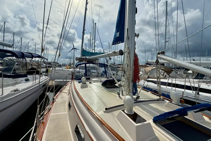 Blue Skies Yacht Photos Pics 1995 Island Packet 40 sailboat docked in a marina under cloudy skies.