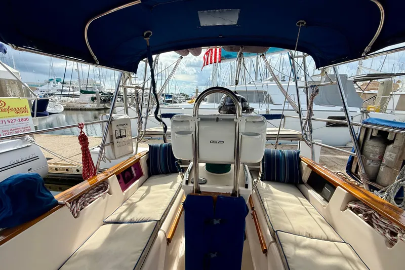 Blue Skies Yacht Photos Pics Cockpit of 1995 Island Packet 40 sailboat docked at marina, featuring cushioned seating and steering wheel.