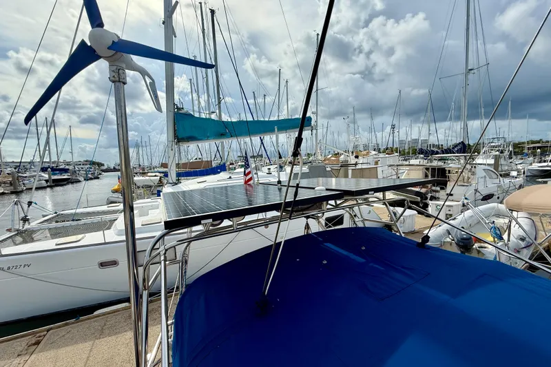 Blue Skies Yacht Photos Pics 1995 Island Packet 40 sailboat docked in marina, featuring solar panels and wind turbine.