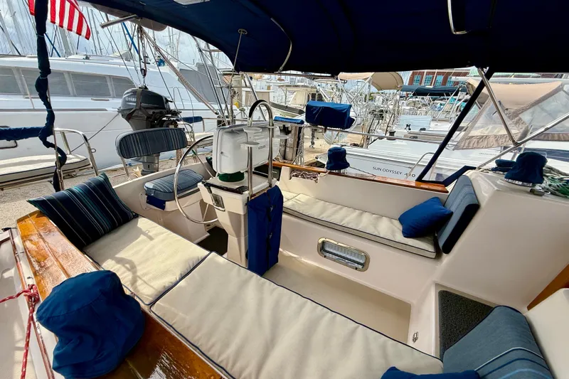 Blue Skies Yacht Photos Pics 1995 Island Packet 40 sailboat cockpit with cushioned seating and steering wheel.