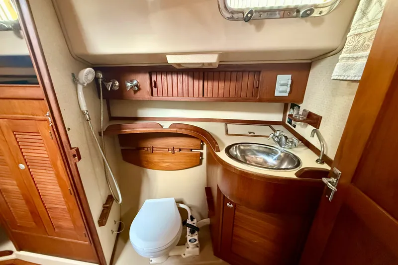 Blue Skies Yacht Photos Pics 1995 Island Packet 40 yacht bathroom with wooden cabinetry and stainless steel sink.
