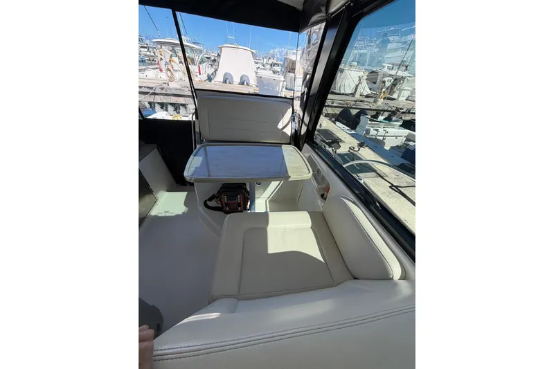  Yacht Photos Pics Interior of 2023 Boston Whaler 345 Conquest with seating and table, docked at marina.