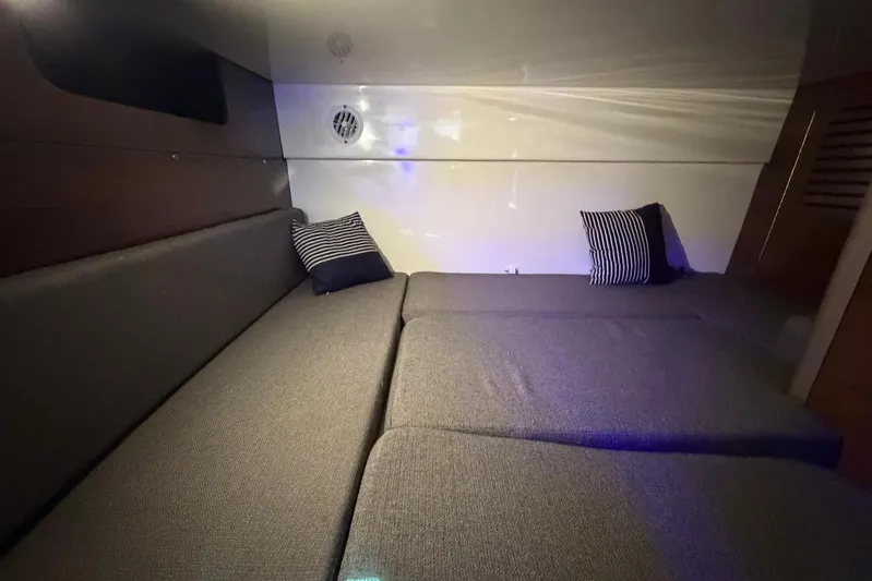  Yacht Photos Pics 2023 Boston Whaler 345 Conquest cabin interior with striped pillows and cozy seating.
