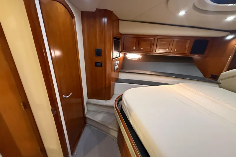  Yacht Photos Pics Luxurious 2007 Cruisers Yachts 560 Express cabin interior with wood finish and cozy bed.