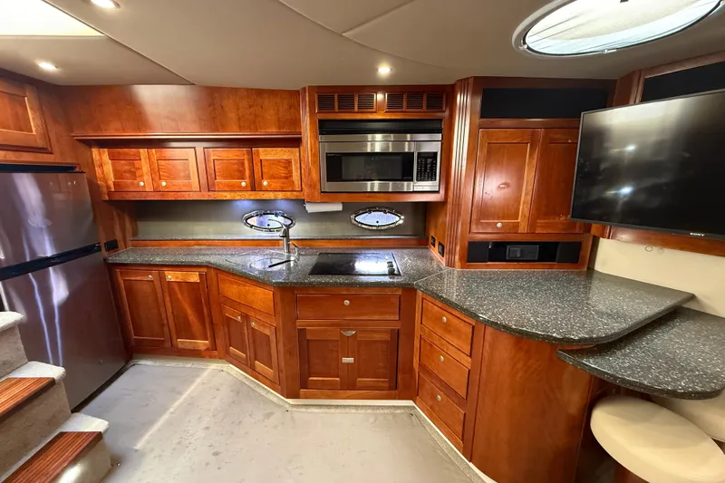  Yacht Photos Pics Luxurious 2007 Cruisers Yachts 560 Express kitchen with wood cabinetry and modern appliances.