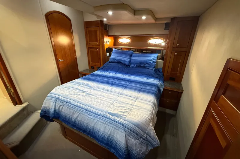  Yacht Photos Pics Luxurious bedroom interior of 2007 Cruisers Yachts 560 Express with blue bedding.