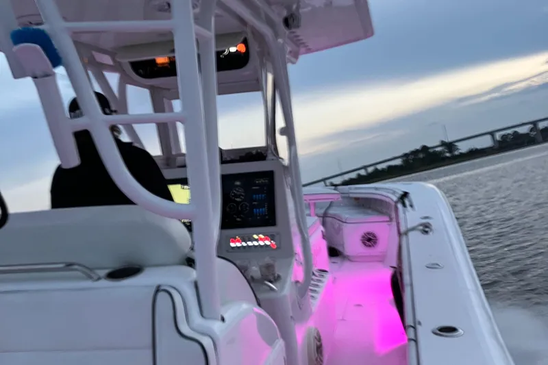  Yacht Photos Pics 2007 Yellowfin 36 boat with illuminated pink interior lights, cruising on water at dusk.