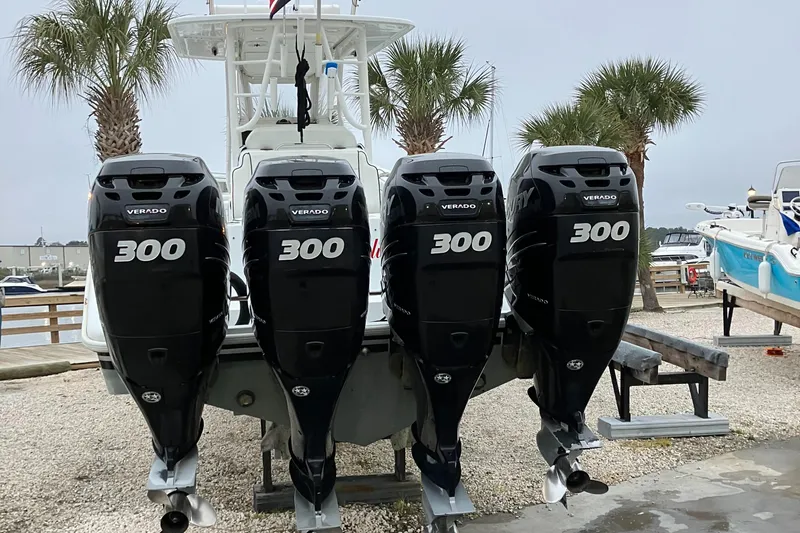  Yacht Photos Pics 2007 Yellowfin 36 boat with four 300 horsepower outboard engines, docked near palm trees.