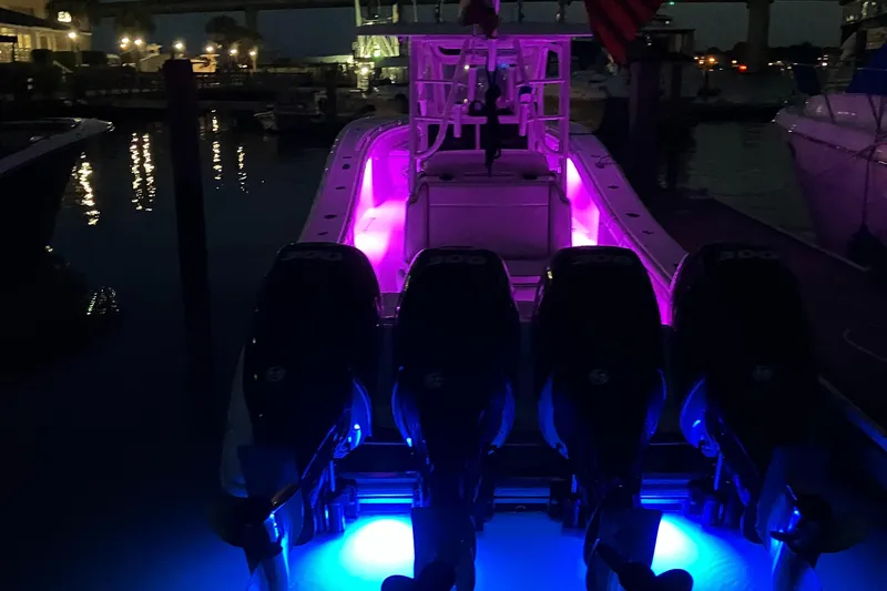  Yacht Photos Pics 2007 Yellowfin 36 boat with vibrant purple and blue LED lights at night.