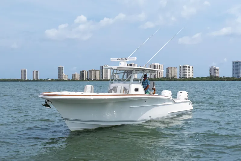  Yacht Photos Pics 2026 Buddy Davis 34 Center Console boat cruising on water with city skyline backdrop.