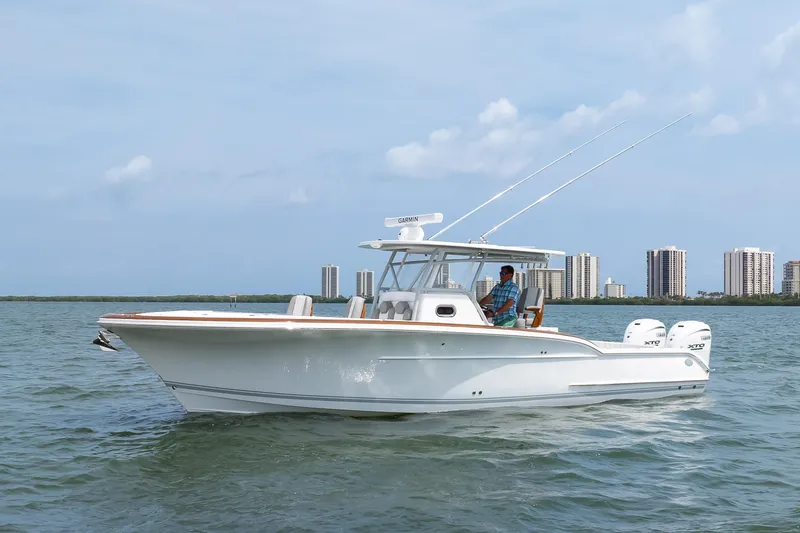  Yacht Photos Pics 2026 Buddy Davis 34 Center Console boat cruising on water near city skyline.