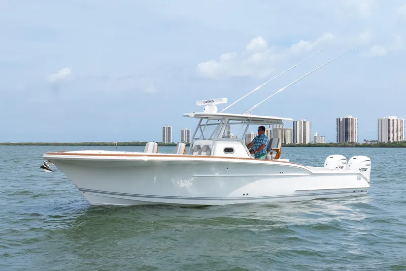  Yacht Photos Pics 2026 Buddy Davis 34 Center Console boat cruising on water near city skyline.