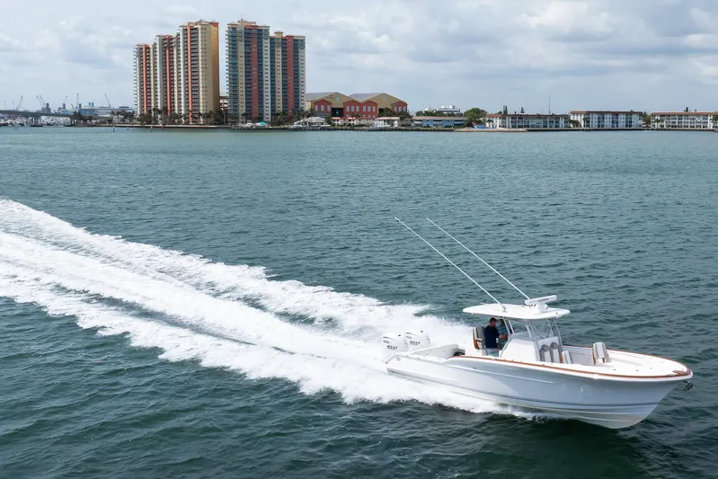  Yacht Photos Pics 2026 Buddy Davis 34 Center Console boat cruising on water near coastal buildings.