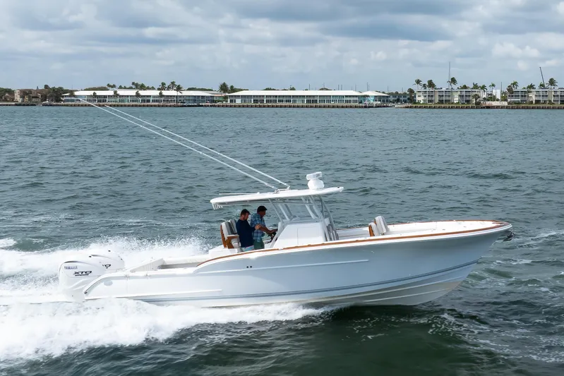  Yacht Photos Pics 2026 Buddy Davis 34 Center Console boat cruising on water with coastal buildings in background.