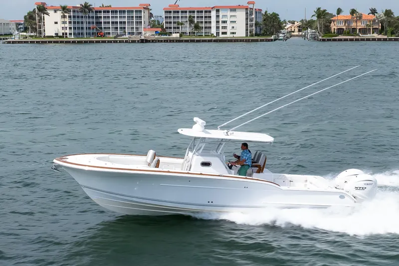 Yacht Photos Pics 2026 Buddy Davis 34 Center Console cruising on water near coastal buildings.
