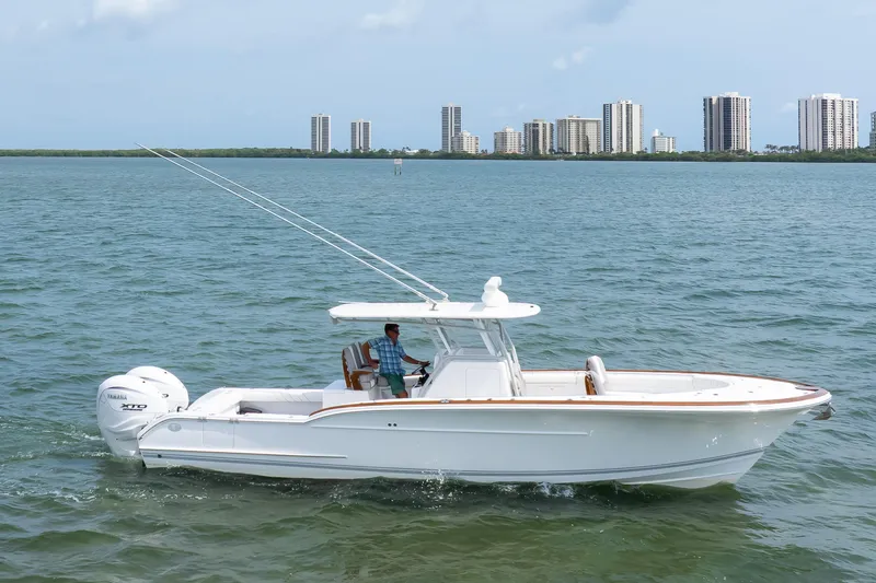  Yacht Photos Pics 2026 Buddy Davis 34 Center Console boat cruising on water with city skyline backdrop.