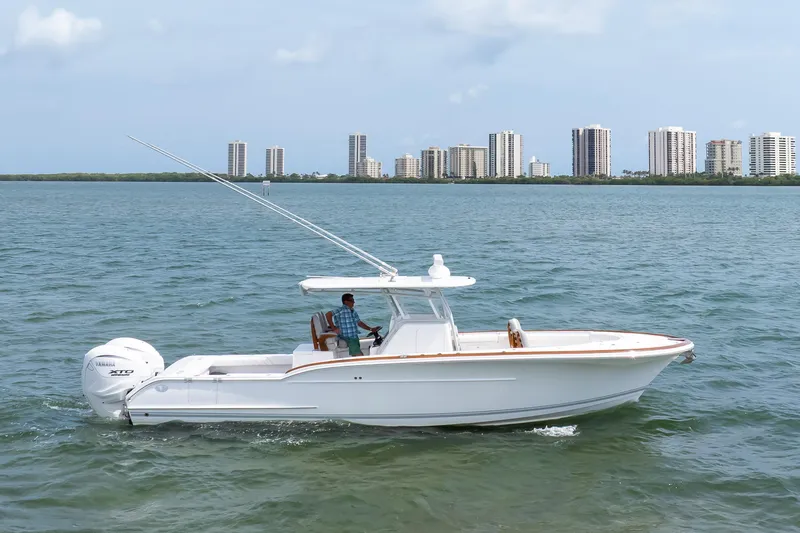  Yacht Photos Pics 2026 Buddy Davis 34 Center Console boat cruising on water with city skyline backdrop.