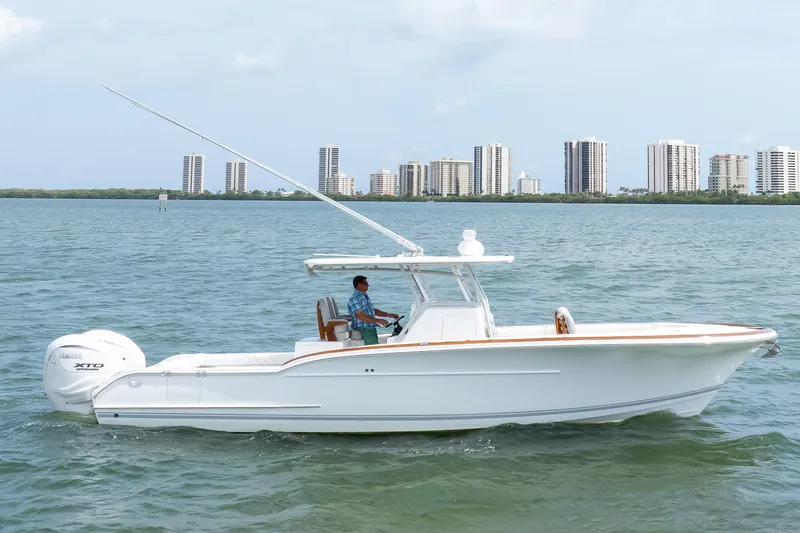  Yacht Photos Pics 2026 Buddy Davis 34 Center Console boat cruising on water with city skyline backdrop.