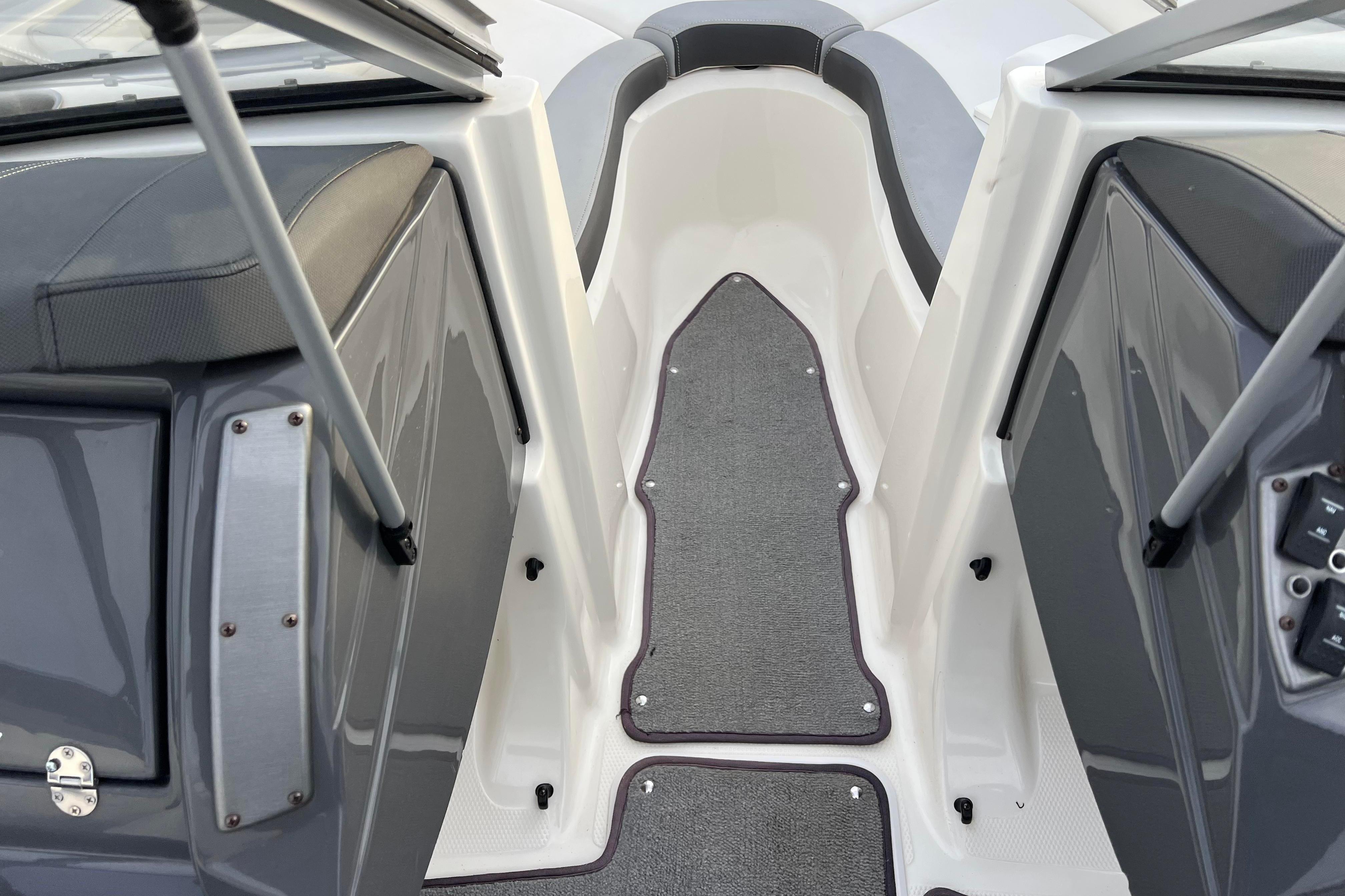 Interior view of 2013 Larson LX 205S IO boat, featuring gray seating and carpeted flooring.