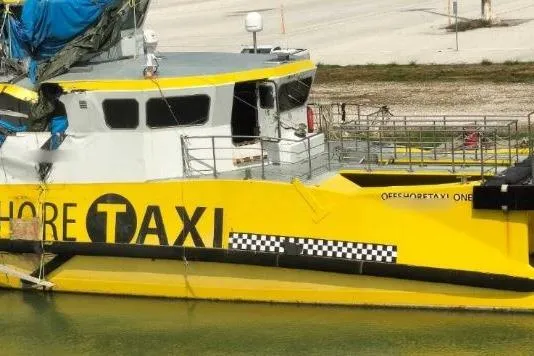  Yacht Photos Pics Yellow Offshore Fast Crew Taxi Catamaran by Mützelfeldtwerft, 2016, docked at a marina.