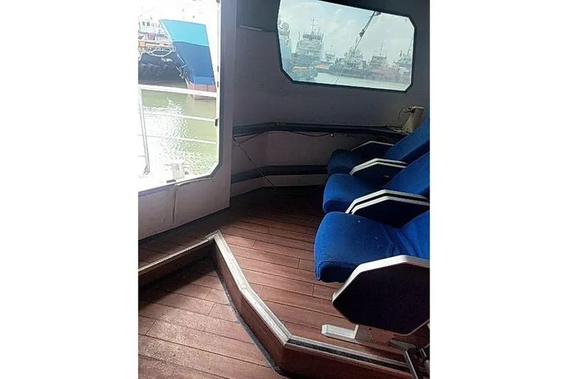  Yacht Photos Pics Interior of 2016 Mützelfeldtwerft Offshore Fast Crew Taxi Catamaran with blue seats and wooden floor.