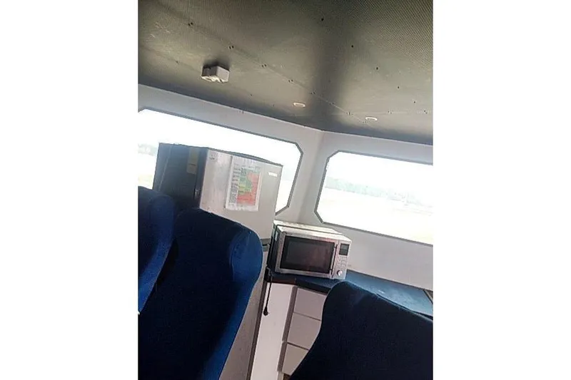  Yacht Photos Pics Interior of 2016 Mützelfeldtwerft Offshore Fast Crew Taxi Catamaran with microwave and seating.