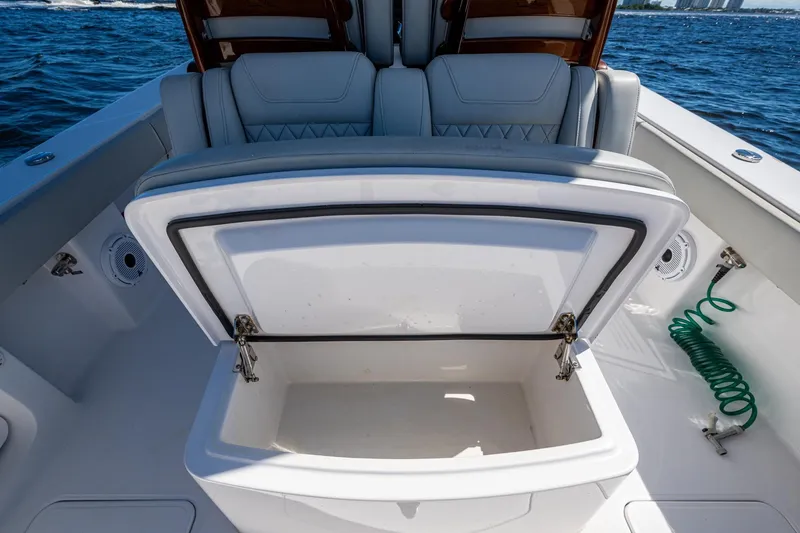  Yacht Photos Pics Open storage compartment on 2022 Jupiter 32 boat, with cushioned seating and ocean backdrop.