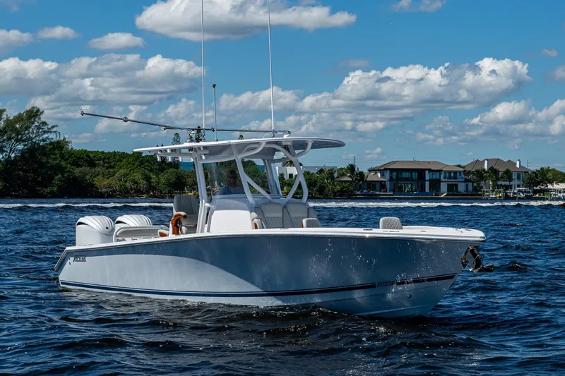  Yacht Photos Pics 2022 Jupiter 32 boat cruising on a sunny day with coastal homes in the background.