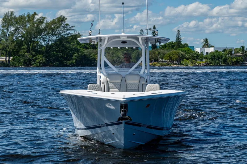  Yacht Photos Pics 2022 Jupiter 32 boat cruising on a sunny day with lush greenery in the background.