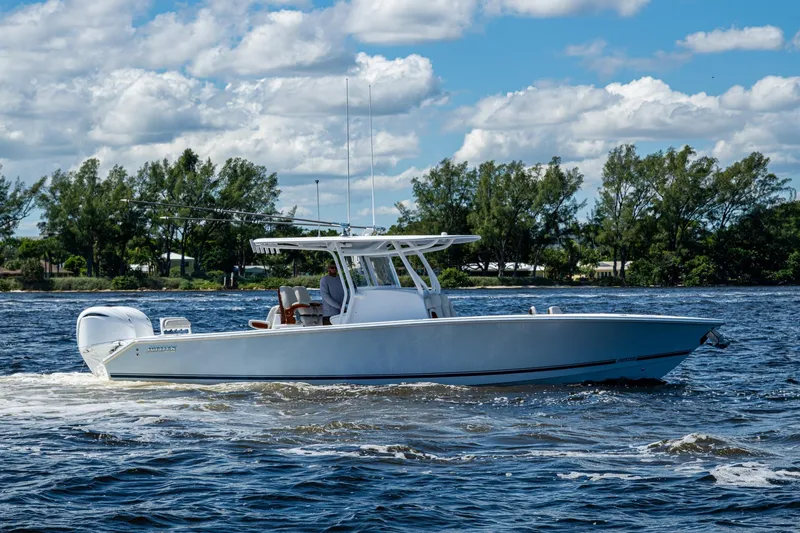  Yacht Photos Pics 2022 Jupiter 32 boat cruising on a sunny day with trees in the background.