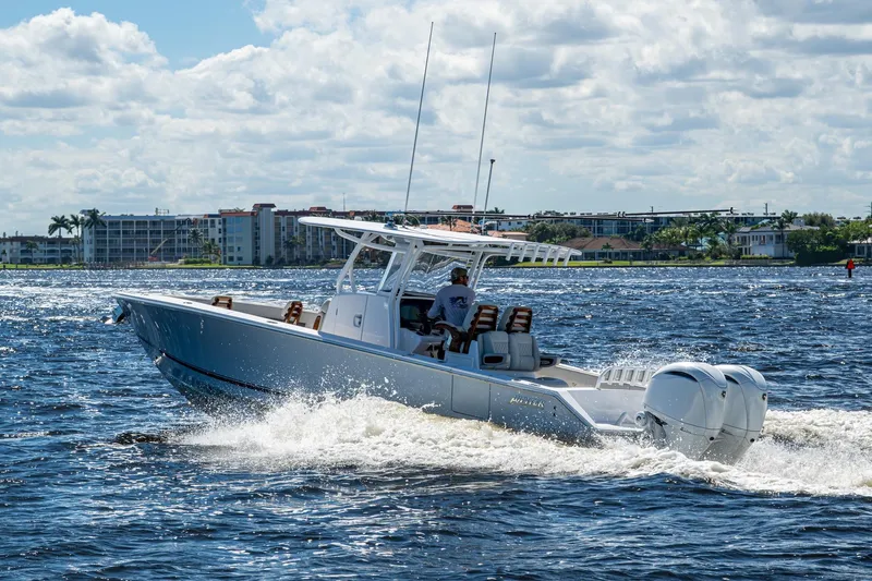  Yacht Photos Pics 2022 Jupiter 32 boat cruising on a sunny day with buildings in the background.