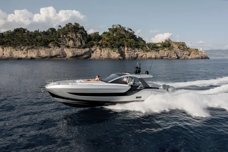  Yacht Photos Pics 2025 Azimut Verve 48 yacht cruising near rocky coastline under clear sky.