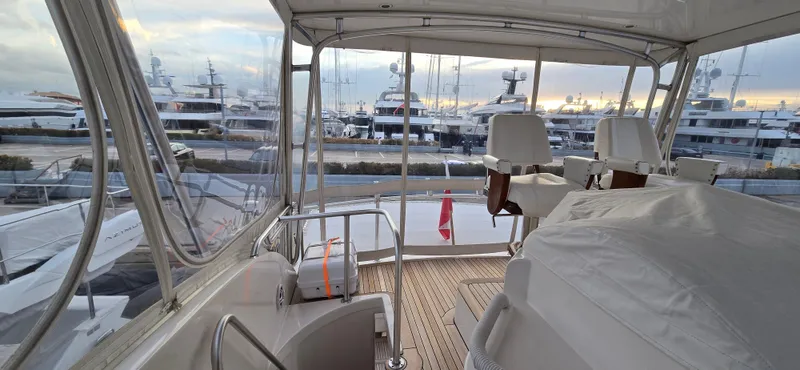 Bouki Yacht Photos Pics Bertram 670 yacht interior, 2006 model, overlooking marina with multiple yachts at sunset.