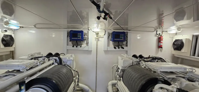 Bouki Yacht Photos Pics Engine room of 2006 Bertram 670 yacht with dual engines and control panels.