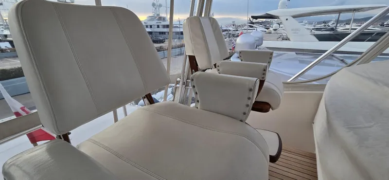 Bouki Yacht Photos Pics Luxury seating on a 2006 Bertram 670 yacht, docked at a marina.