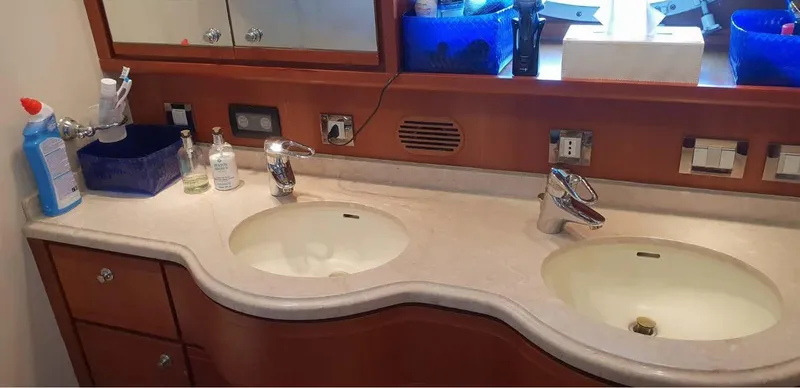 Bouki Yacht Photos Pics Luxury Bertram 670 yacht bathroom with dual sinks, elegant fixtures, and wooden cabinetry, 2006 model.