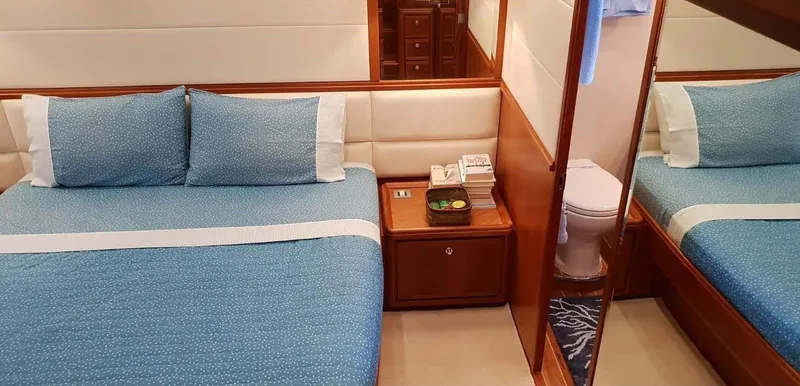 Bouki Yacht Photos Pics Luxurious Bertram 670 yacht bedroom with blue bedding, 2006 model.