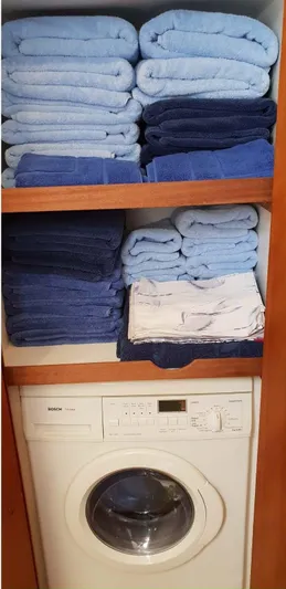 Bouki Yacht Photos Pics Neatly stacked blue towels above a washing machine in a Bertram 670, 2006 model.