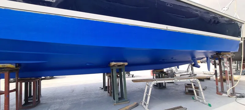 Bouki Yacht Photos Pics Bertram 670 boat from 2006 on stands, showcasing a vibrant blue hull.