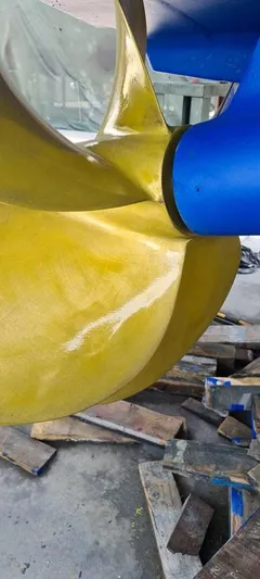 Bouki Yacht Photos Pics Close-up of a 2006 Bertram 670 boat propeller, showcasing its yellow and blue design.