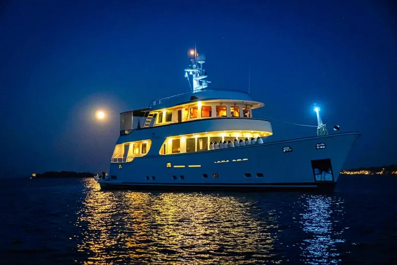 Annamia Yacht Photos Pics Luxurious 2007 Terranova Yachts T85 illuminated at night on calm waters.