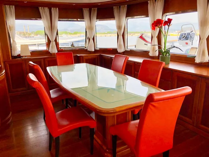 Annamia Yacht Photos Pics Luxurious dining area on 2007 Terranova Yachts T85 with red chairs and panoramic windows.