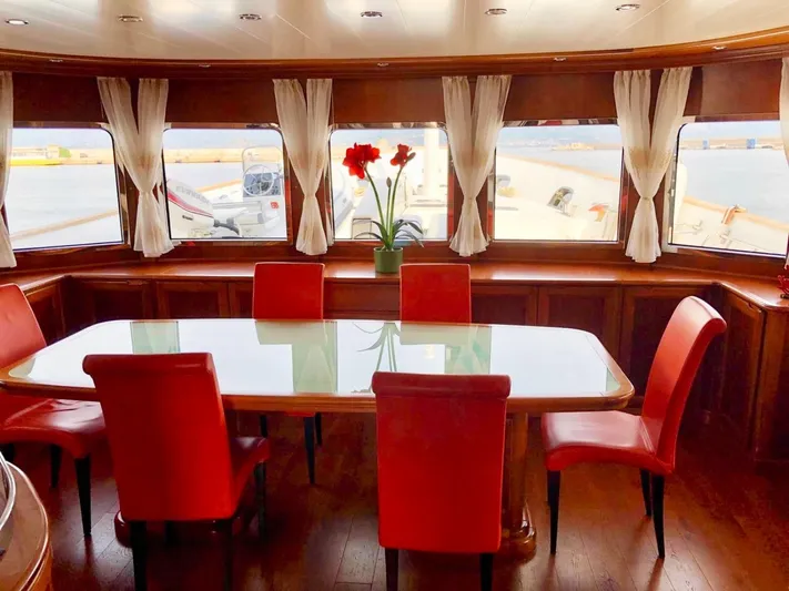 Annamia Yacht Photos Pics Luxurious dining area on 2007 Terranova Yachts T85 with red chairs and large windows.
