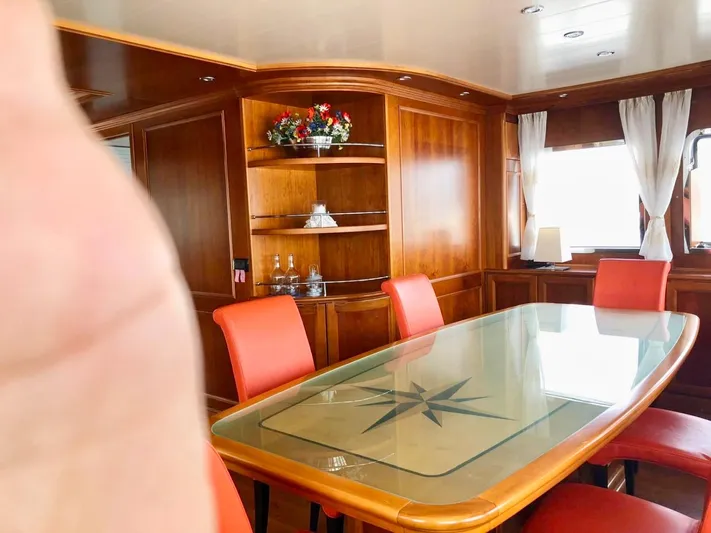 Annamia Yacht Photos Pics Luxurious dining area on 2007 Terranova Yachts T85 with elegant wood paneling and red chairs.