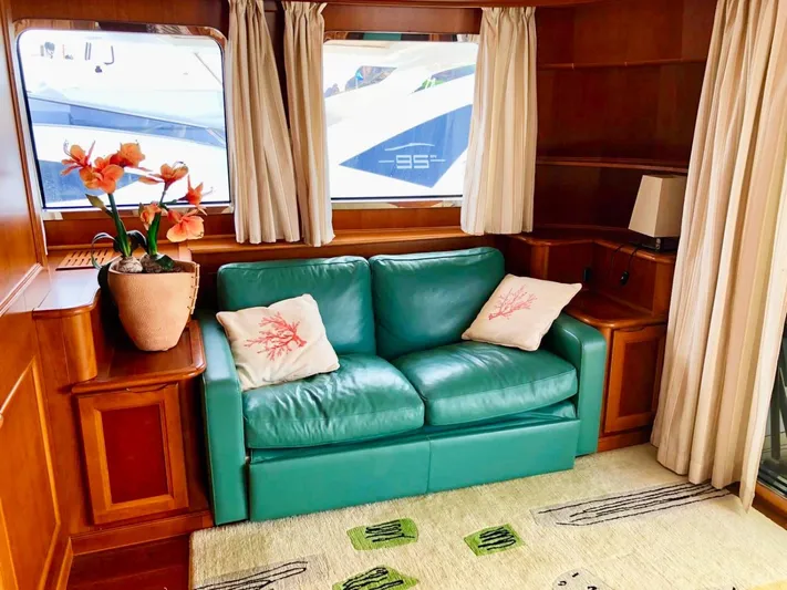 Annamia Yacht Photos Pics Luxurious Terranova Yachts T85 2007 interior with teal sofa, floral decor, and wooden accents.