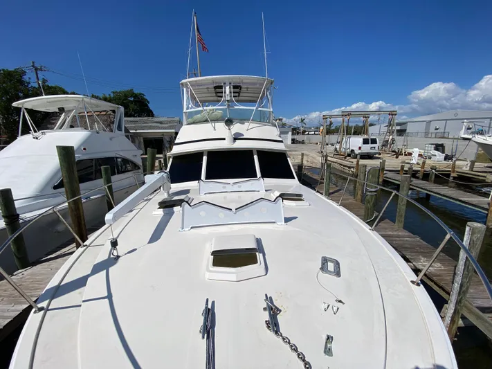  Yacht Photos Pics 1982 Bertram 46.6 War Wagon yacht docked at marina under clear blue sky.