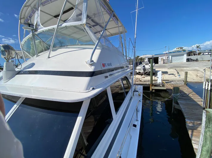  Yacht Photos Pics 1982 Bertram 46.6 War Wagon docked, showcasing sleek design and spacious flybridge.
