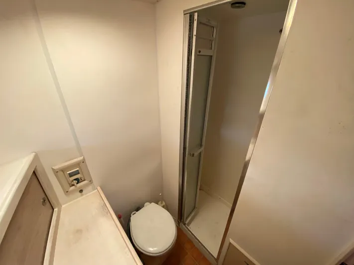  Yacht Photos Pics Bathroom interior of 1982 Bertram 46.6 War Wagon yacht, featuring shower and toilet.