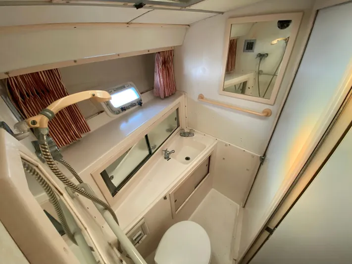  Yacht Photos Pics 1982 Bertram 46.6 War Wagon bathroom with shower, sink, and mirror.